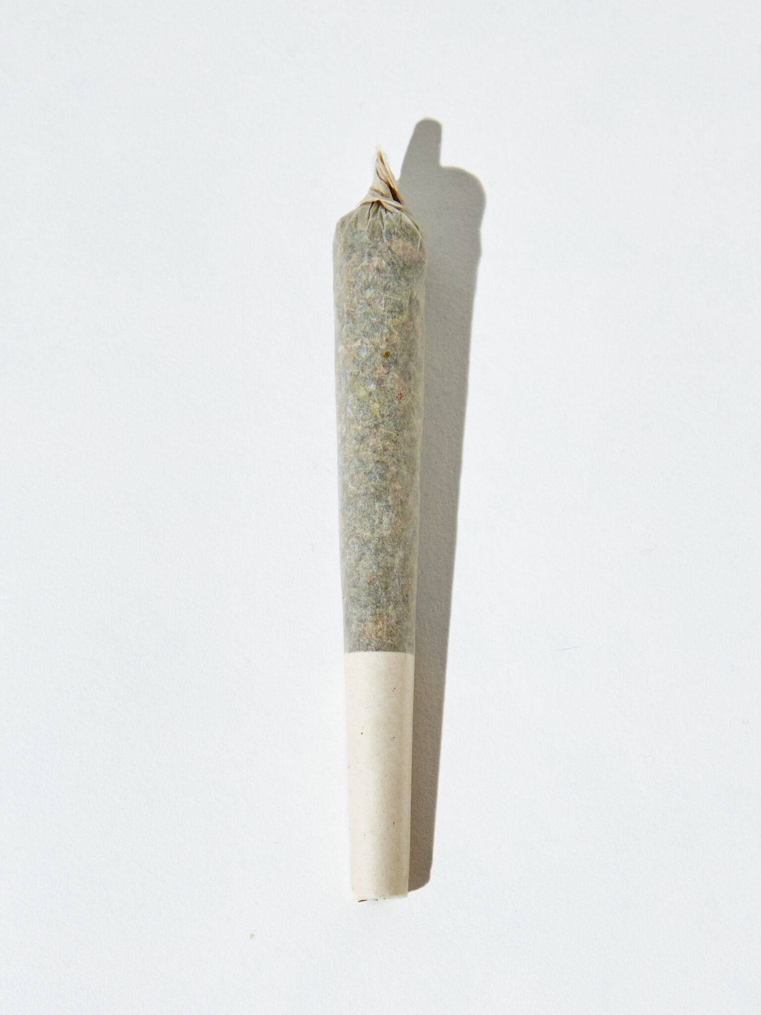 Vertical isolated shot of a THCa pre-roll joint on white background